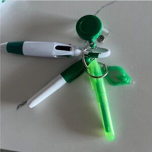 Badge reel with highlighter, small light, marker, and multicolored pen.